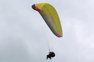 Tandem Paraglider flying wing in a cloudy sky	