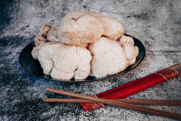 Hericium erinaceus or Lions mane mushrooms on a plate with Chinese sticks. © stivog