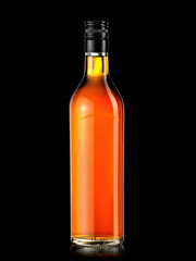 Dark rum bottle with black cap isolated on black background