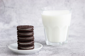 Chocolate shortbread cookies with cream filling, served with milk.
