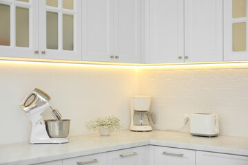 Fototapeta na wymiar Modern toaster and household appliances on counter in kitchen