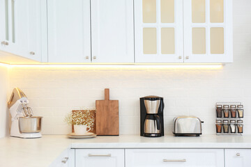 Modern toaster and household appliances on counter in kitchen