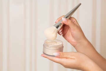 Woman with a brush using mineral powder
