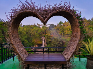 Love shaped sit for couple tourist in bali with the Tegenungan waterfall in the background in Indonesia © Asif