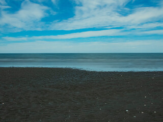 Playa de arena con aguas claras y cielo nublado