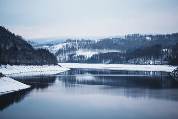 Winter landscape at Soesetalsperre in Harz Mountains National Park, Germany. Moody snow scenery in Germany