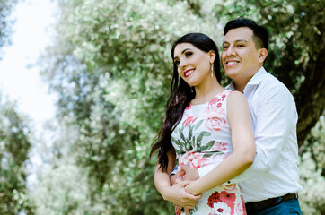 Happy young couple hugging and laughing outdoors