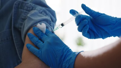 Young Asia lady nurse giving Covid-19 or flu antivirus vaccine shot to senior male patient wear face mask protection from virus disease at health clinic or hospital office. Vaccination concept. - Powered by Adobe