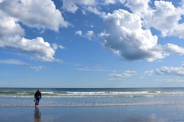 Fototapeta na wymiar solitary man wading in shallow surf on the New England coast