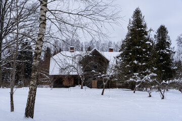 deep snow, where you can see some trees and an old abandoned wooden building