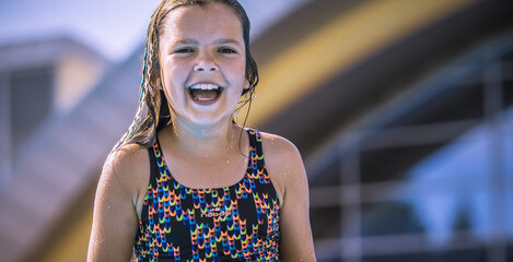 Uśmiechnięta i szczęśliwa dziweczynka na wakacjach podczas kolonii letnich nad morzem, na basenie w stroju kąpielowym © Beenis