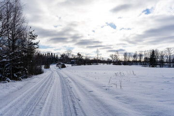 Obraz premium road in the middle of the field that is covered with snow