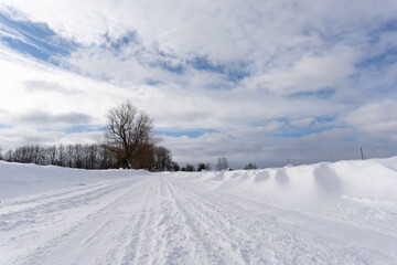 Fototapeta na wymiar road in the middle of the field that is covered with snow