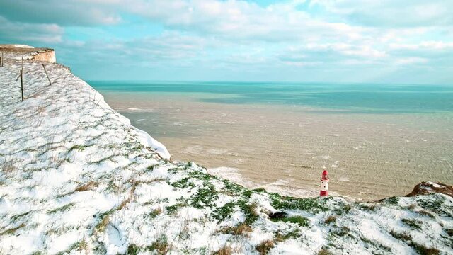 Beachy Head Lighthouse Located In The English Channel, East Sussex In 4K. Beautiful View Of A Lighthouse At The Seashore During Winter Surrounded By Waves Of The Ocean In Slow Motion.