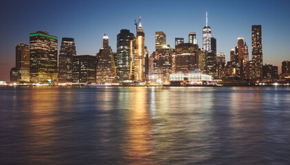 Manhattan skyline reflected in water at dusk, New York City, USA.