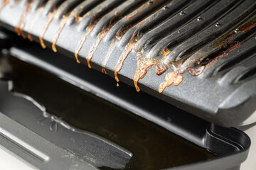 dirty after cooking electric grill with open lid. appliance for cooking in everyday life. Made of...