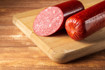 Sliced salami sausage on cutting board. Food idea preparation before the holiday