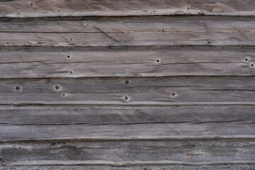 close up of an old wooden log building with gray old logs