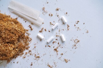 Fine cut smoking tobacco, smoking filters and rolling papers on white background shot from top....
