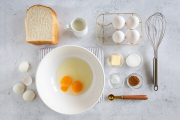 Flay lay of ingredients for making french toast (or wentelteefjes in Dutch) on white grey background, view from above
