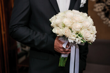 Bouquet of flowers in the groom's hand