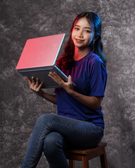 Beautiful young woman, charming business CEO holding notebook wearing blank t-shirt while stylish isolated background. Portrait of a happy and excited woman with a laptop. Models for new notebook.