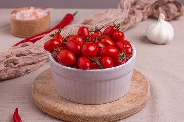Fermented red cherry tomatoes in a white plate. Vegetarian food. Salted tomatoes. Pickled organic tomatoes. Homemade fermented foods. Food stocks.