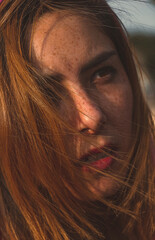 Mujer pelirroja con pecas mirando al sol