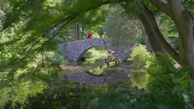 Young Couple on Stone Bridge Over a Small Pond in Roslyn Long Island