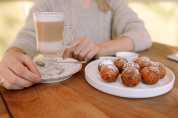 Closeup cup with latte and donuts on a plate