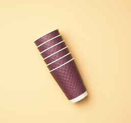stack of purple disposable paper cups on beige background