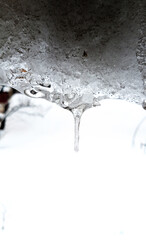 An icicle hanging from the edge of the roof.