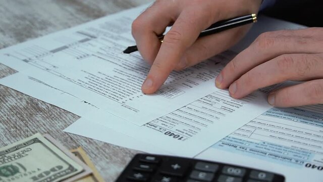 Man filling US tax form. tax form us business income office hand fill concept. Tax Return Form 1040