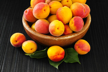 Organic apricots in a wooden bowl. Low key.