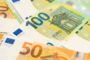 Banknotes background. Fifty and one hundred Euro notes in orange and green color covering the floor. Currency of Europe.