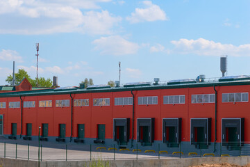 New logistics center with closed gates and an empty car area in front of it.
