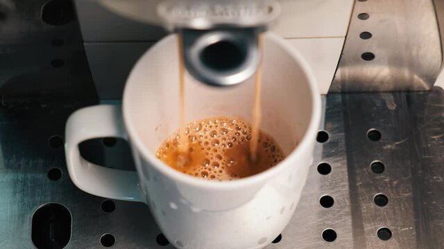 Coffee machine pouring coffee with into a cup