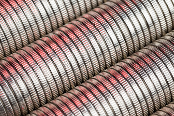 many round metal coins of silver color illuminated in red