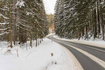 Asfaltowa droga przebiegająca przez Góry Izerskie. Polska zimą. © boguslavus