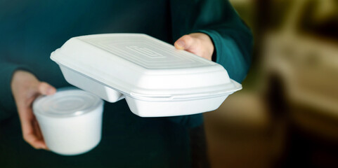 Hand holding foam boxes. Take away food to customers at the restaurant bar to prevent the spread of...