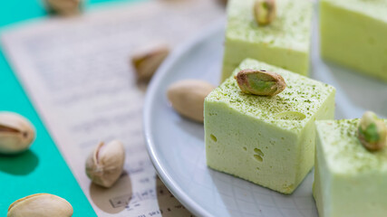 Handmade souffle candy with pistachioon on a bright background. Homemade sweets or candies. Pistachio souffle.