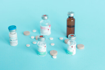 Various medical ampoule and pills isolated on blue background.