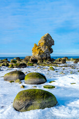 Cold winter day with ice on the water with a limestone stack and ocean in the background on the island of Gotland in Sweden