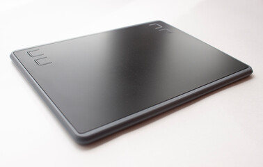 Black graphic design tablet. A graphic tablet at an angle for working on a computer.