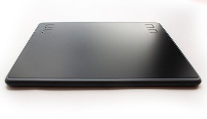 Black graphic design tablet. A graphic tablet at an angle for working on a computer.