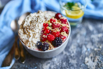 Recipe ideas for summer diet breakfast, healthy morning dessert in portioned soup plate with summer berries - raspberry, cherries, blackberry. On stone background.