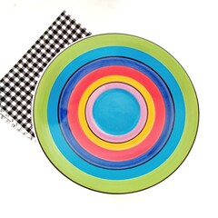 Rainbow tiled plate with black and white napkin on white background