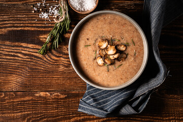 Mushroom cream soup served on rustic wooden  dinner table