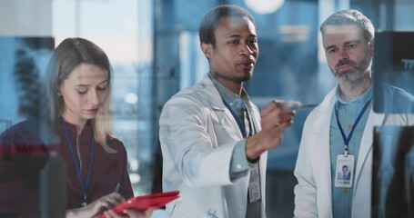 Multi-ethnic trip of medical people discussing x-ray pictures and disease symptoms in modern healthcare office private clinic hospotal. - Powered by Adobe
