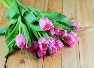 Wiosenne tulipany kwiaty różowe na tle drewnianych desek